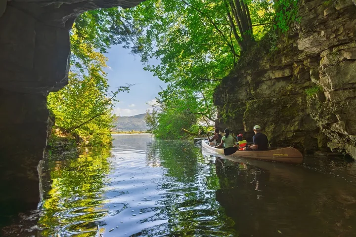 Družina na kanuju na Cerkniškem jezeru v jami Skadulci.