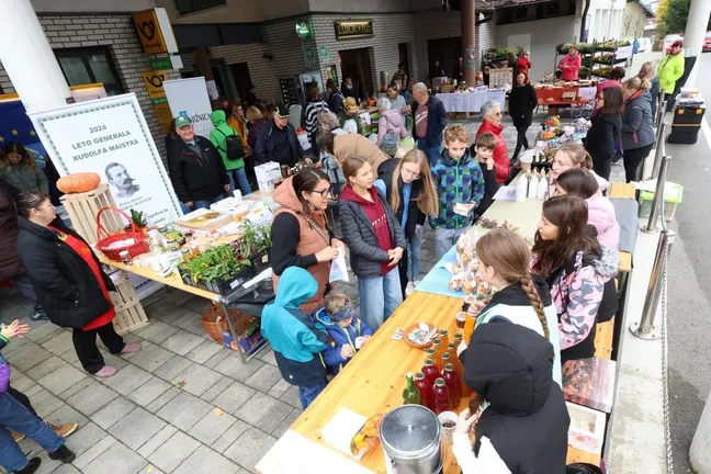 The atmosphere at the Flower Fair in Rakek, visitors are photographed from above, sitting and standing at the stands, tables with juices, honey, vegetables and plants.