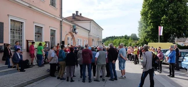 Large group of hikers gathered in front of a building in Rakek.
