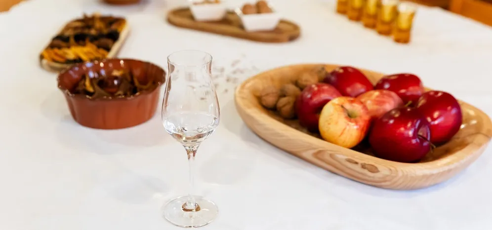 Tasting glass beside apples, walnuts and dried fruit.