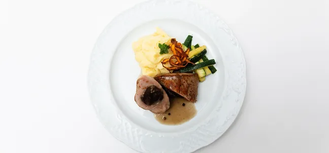 Pork tenderloin with plum, mashed potatoes and pumpkin strips with garlic.