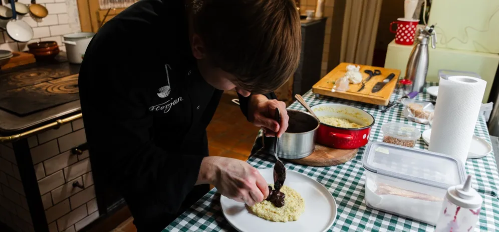 Chef pripravlja glavno jed s kremno polento v Notranjski hiši.
