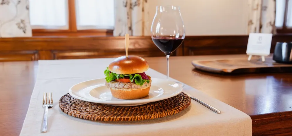 Burger in kozarec rdečega vina, postrežena na Posestvu Bajer.