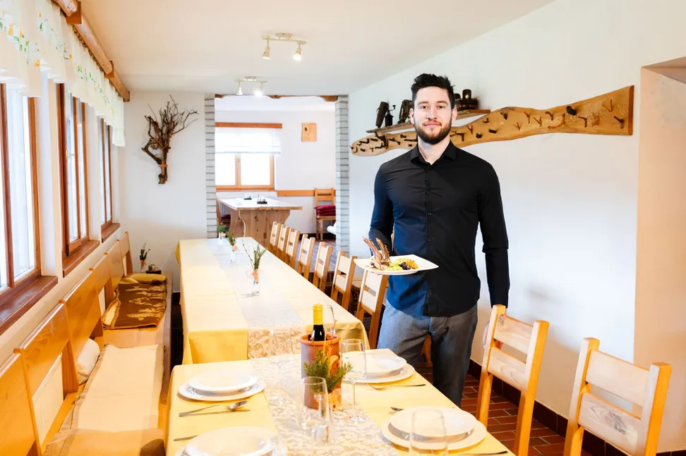 Serving a meat dish in the dining room at tourist farm Strle.