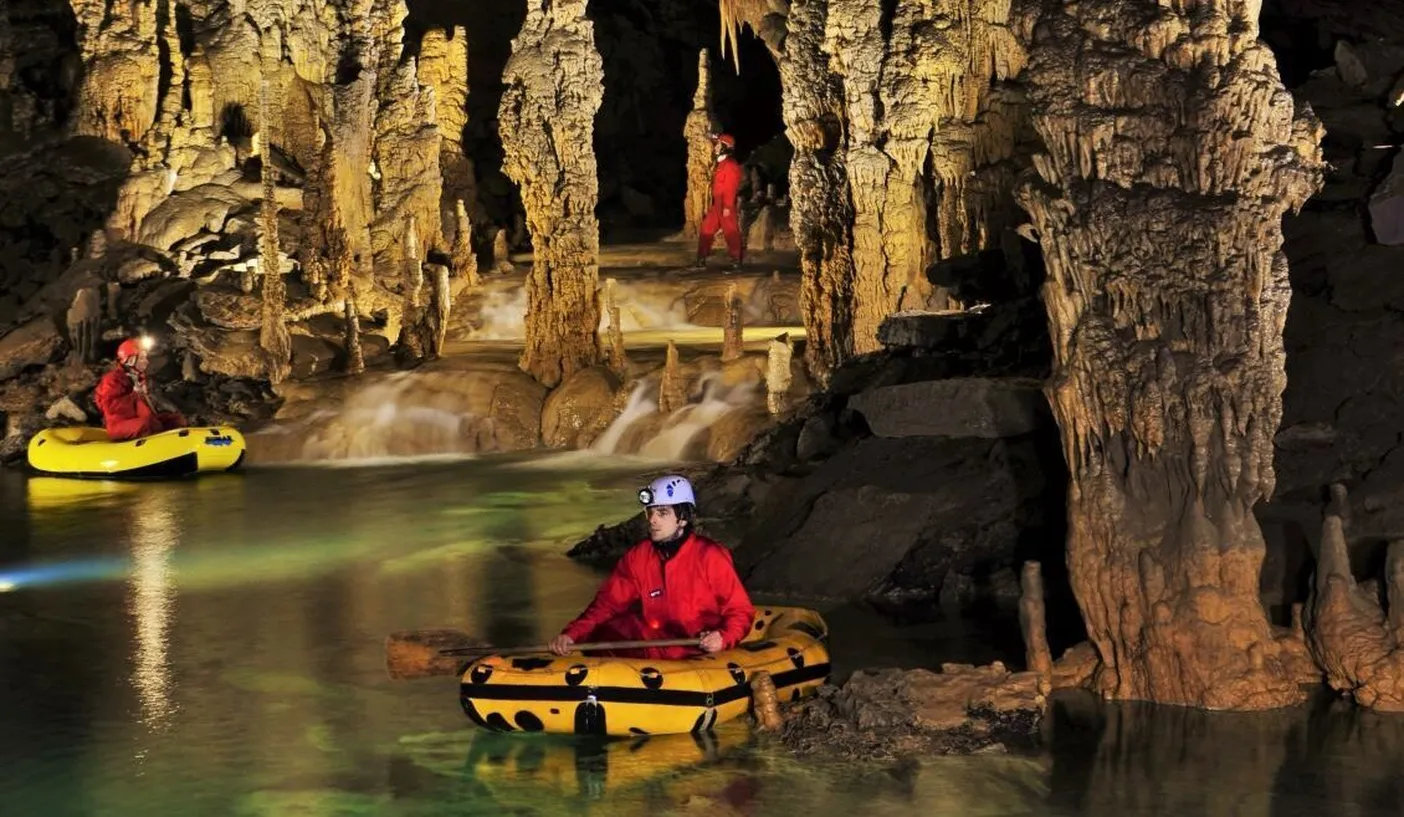 Cavers row in inflatable boats on the underground lake of Križna cave.