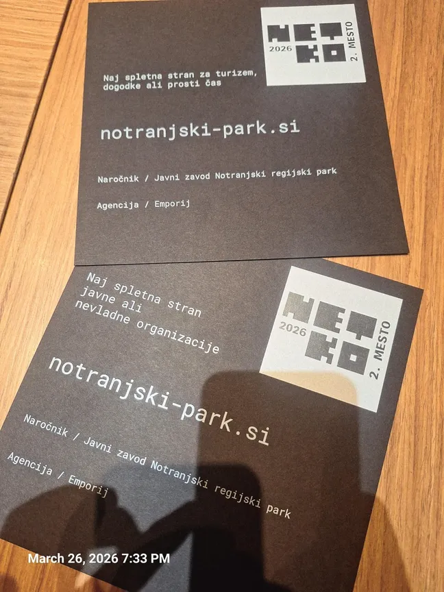 Dve plaketi nagrade NETKO 2026 za spletno stran Notranjskega parka na leseni podlagi.