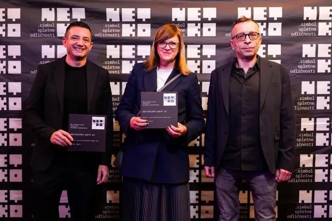 Trije udeleženci na prireditvi NETKO v Ljubljani držijo plakete za 2. mesto za spletno stran Notranjskega parka.