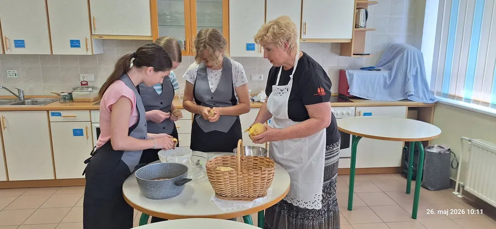 Udeleženke kuharske delavnice pod vodstvom mentorice pripravljajo kolerabo za tradicionalno jed.