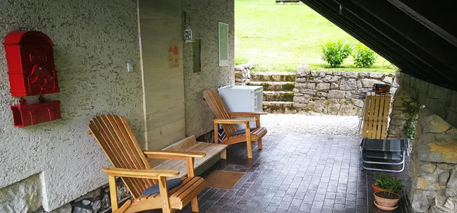 Lake view holiday home-Zunanji prostor za sprostitev pod nadstreškom z lesenima stoloma, mizico in rustikalnim zidom – prijetna terasa z naravnimi elementi in dostopom do vrta.