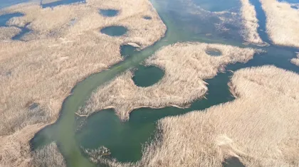 Cerkniško jezero posneto z dronom iz zraka, kjer lahko opazujemo jezerska okna.