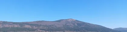 Slivnica v jesenskih barvah in modrin nebom nad njo.
